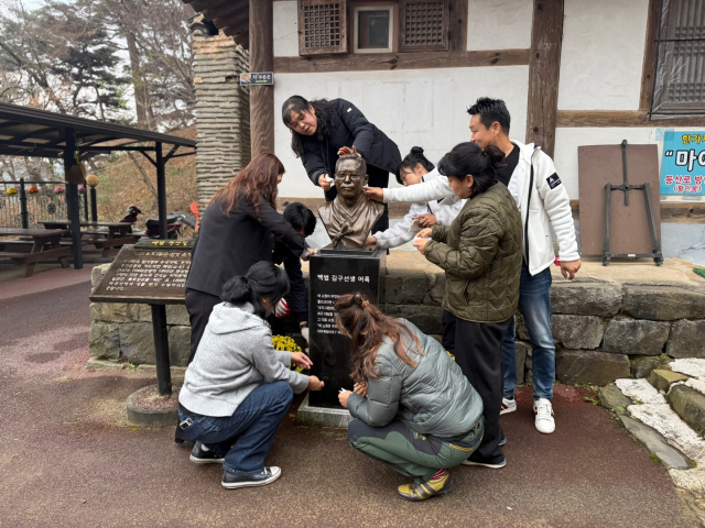 백범 김구 선생 흉상 주변의 유지.보수를 하고 있는 민주평통 공주시협의회원들 모습.사진=김익환 기자