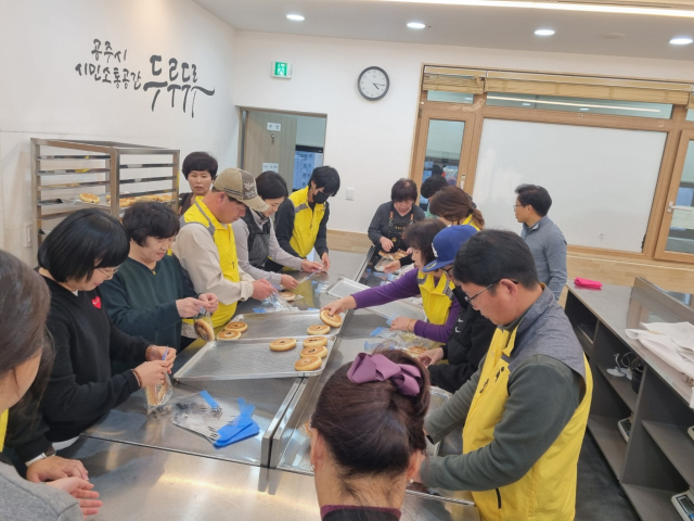 어르신들에게 전달할 빵을 만드는 회원들 모습.사진=김익환 기자