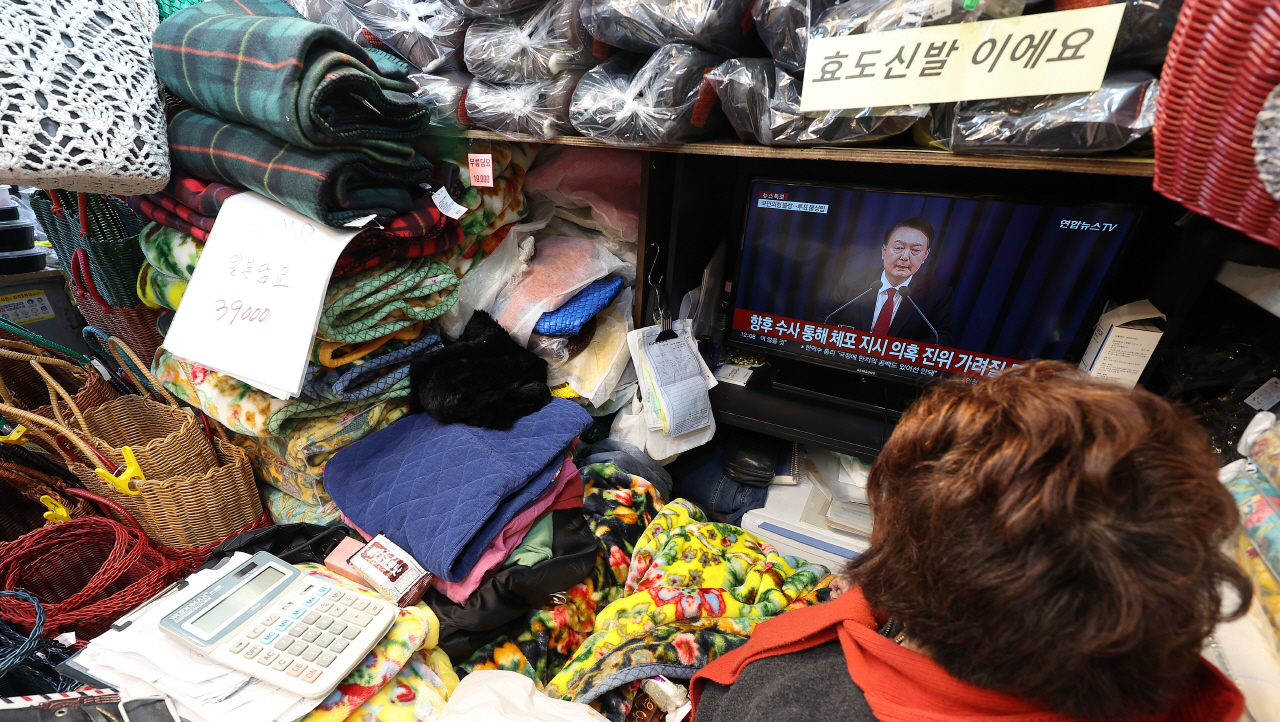  8일 오전 대구 중구 서문시장에서 한 상인이 '계엄 사태'관련 뉴스를 보고 있다. 2024.12.8 사진=연합뉴스. 