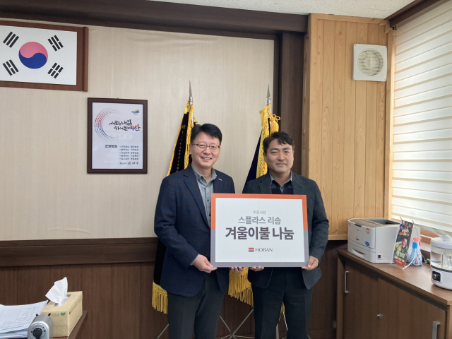 스플라스 리솜 김윤환 총지배인(왼쪽)이 16일 덕산면에 겨울이불을 기탁하고 박찬만 덕산면장과 기념촬영을 하고 있다. 예산군 제공