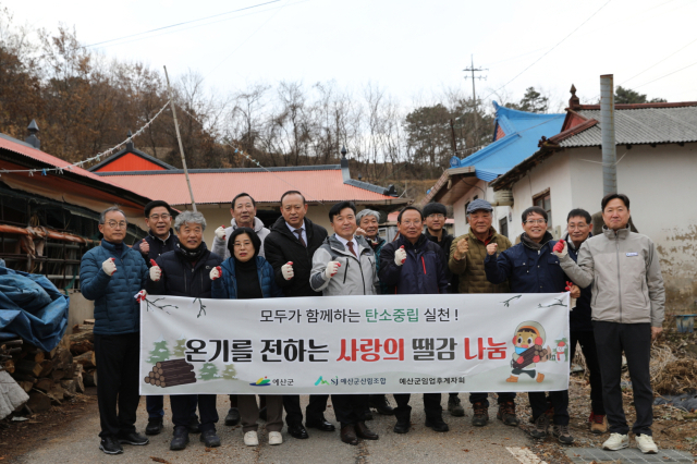 최재구 예산군수, 장순관 예산군의장, 예산군산립조합 관계자들이 지난 16일 땔감 나눔 봉사활동을 펼치고 기념촬영을 하고 있다. 예산군 제공
