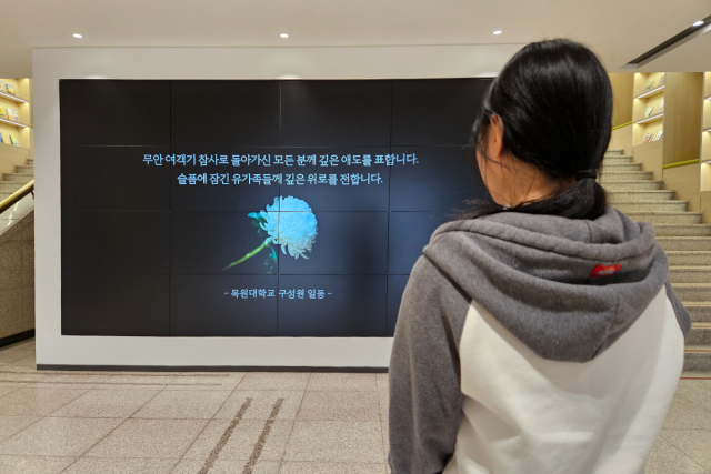 30일 목원대학교 대학본부 1층 로비에서 한 재학생이 무안 제주항공 여객기 참사 희생자들을 추모하며 묵념을 하고 있다.. 목원대학교 제공