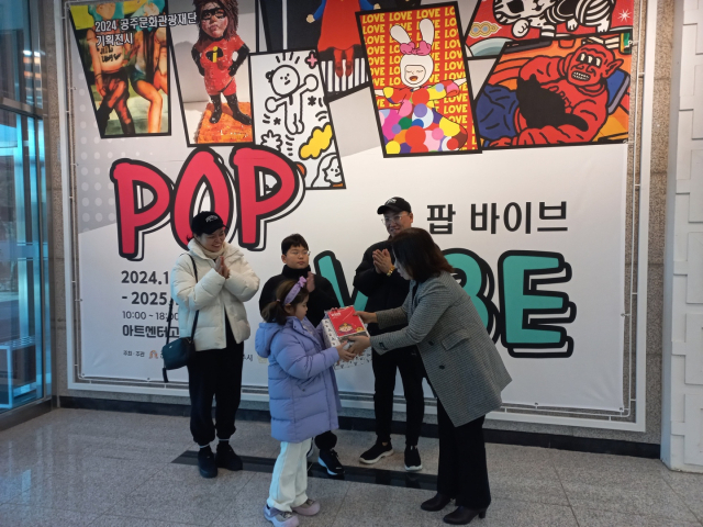 공주문화관광재단 기획전시-팝 바이브(POP VIBE)전’ 첫 번째 관람객에게 기념품 증정 모습.