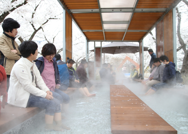 수안보 족욕로드길에 설치된 족욕 온천을 즐기고 있는 관광객. 충주시 제공