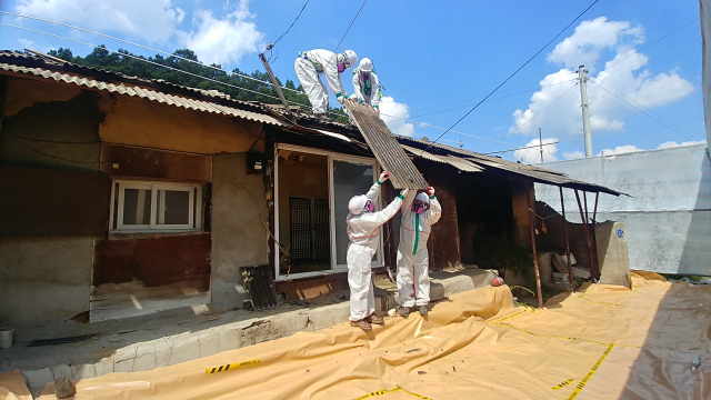 충주시가 지난해 석면 슬레이트 처리 및 개량 지원사업에 선정된 곳에 석면 지붕을 철거를 하고 있는 모습이다.사진=충주시