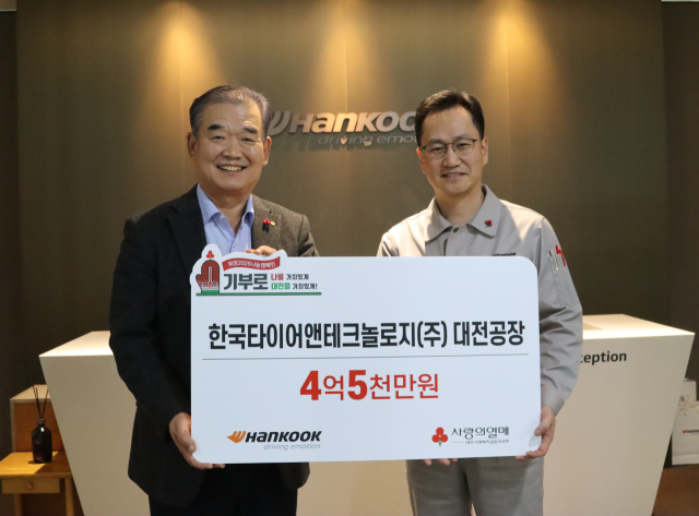 대전사회복지공동모금회 유재욱 회장(사진 좌측), 한국타이어앤테크놀로지(주) 이준길 대전공장장(사진 우측)이 사진을 찍고 있다. 한국타이어 대전공장 제공