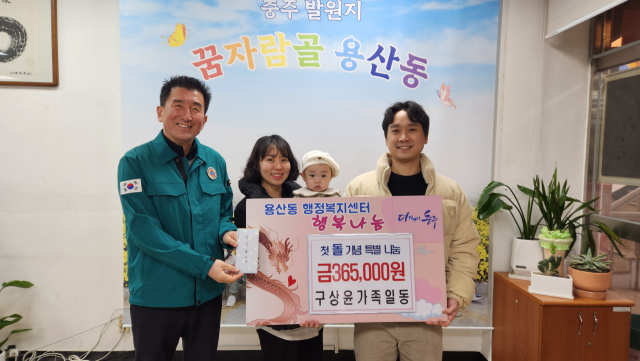 충주용산동 구문수(오른쪽)씨가 아들 첫돌 대신해 매일 1000원씩 모은 돈 36만원을 어려운 이웃을 위해 써달라며 홍대희 동장에게 전달했다.사진=충주시