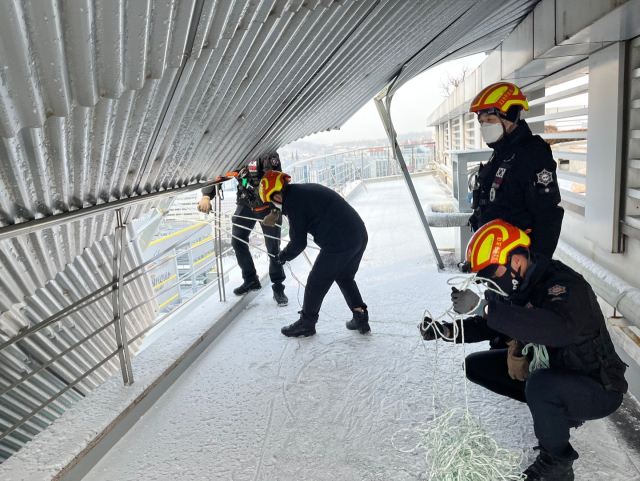 7일 오전 9시8분경 대전 서구 둔산동 15층짜리 오피스텔 건물에서 양철판 구조물이 강풍에 떨어지는 사고가 발생했다. 소방 대원들이 밧줄 등으로 추가 낙하를 위해 안전 조치를 취하는 모습. 대전소방본부 제공