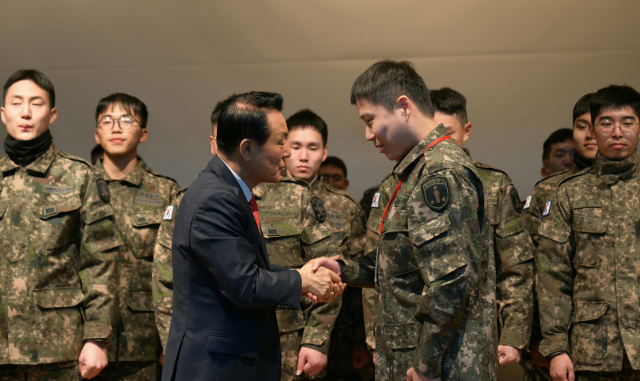 ▲백성현 논산시장이 전역하는 장병들에게 논산시 명예시민 위촉장을 전달하며, 축하의 메세지를 전달하고 있다.