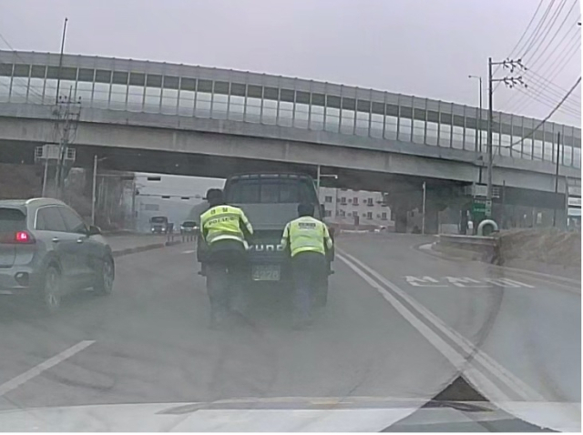경찰관들이 고장 차량을 밀어 안전한 곳으로 이동조치하는 모습. 천안동남서 제공.