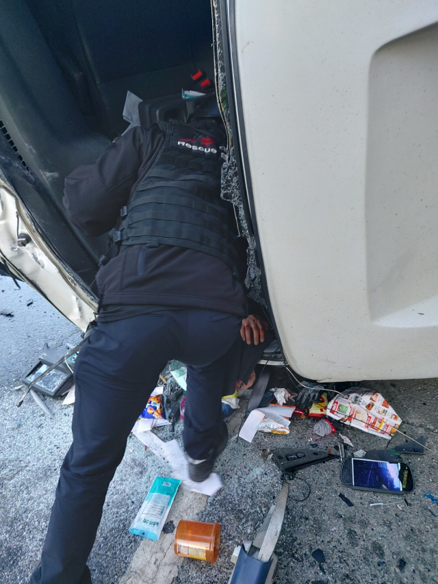 24일 오전 7시22분경 대전 동구 구도동 남대전 IC 금산 방향 부근 도로에서 연쇄추돌사고가 발생한 가운데 출동한 구조대원이 전복된 차량 유리창을 깨고 운전자를 구조하는 모습. 대전소방본부 제공