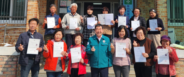 이재영 군수가 요양보호사 마을로 화제를 모으고 있는 덕상3리 마을 주민들과 요양보호사 자격 취득을 축하하며 기념사진을 찍고 있다. 증평군 제공