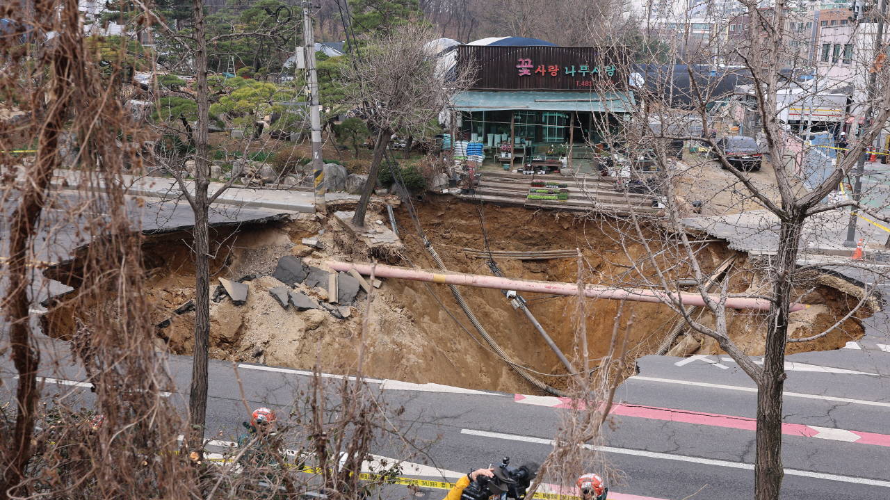 25일 강동구 대명초등학교 도로에서 전날 발생한 대형 땅꺼짐 현장의 모습.전날 오후 명일동 대명초등학교 인근 사거리에서 발생한 지름 20ｍ, 깊이 18ｍ가량의 대형 싱크홀(땅꺼짐)에 오토바이 운전자 1명이 빠져 실종됐다. 2025.3.25 사진=연합뉴스. 