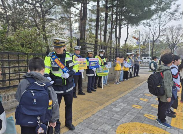 대전서부경찰서 소속 경찰관이 등교하는 어린이에게 안전보행 3원칙(서다·걷다·보다)이 적힌 경찰 밴드를 나눠주고 있다. 대전서부서 제공