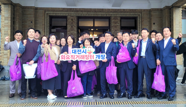 농협중앙회 대전지역본부 임직원 등이 22일 옛 충남도청 광장에 마련된 ‘2025년 화요직거래장터’를 방문해 지역 농축산물을 구입한 뒤 기념촬영을 하고 있다. 대전농협 제공