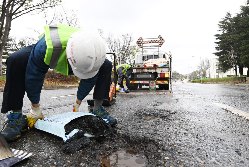 14일 대전 유성구 신성동의 한 도로에서 대전시 관계자들이 포트홀을 메우는 작업을 하고 있다. 김주형 기자 kjh2667_@cctoday.co.kr