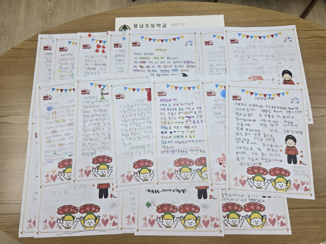 ▲용남초 3학년 5반 학생들이 계룡소방서에 전달한 손편지 모음. 아이들의 정성이 가득 담긴 손글씨와 그림이 눈길을 끈다.