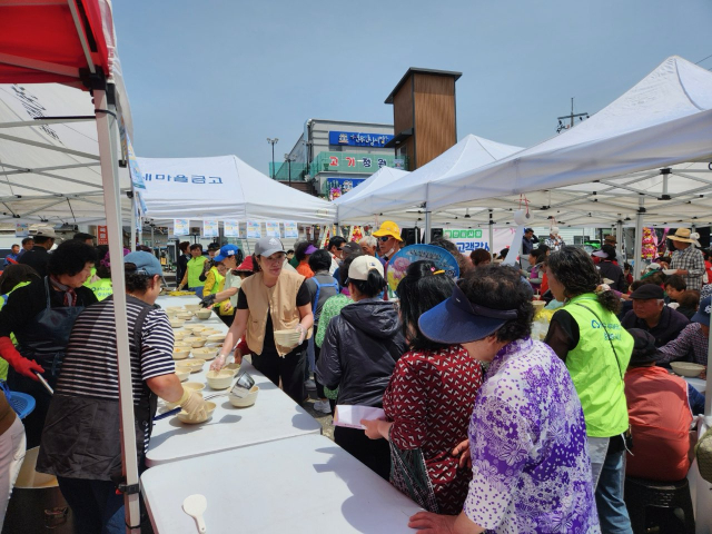 ▲ 충청새마을금고 직원들과 MG충청봉사회, 충청사모회등 봉사단들이 지역 주민들에게 국수를 나눠주는 모습. 밝은 표정으로 국수를 전달하며 따뜻한 마음을 전하는 장면이 훈훈한 분위기를 자아내고 있다.