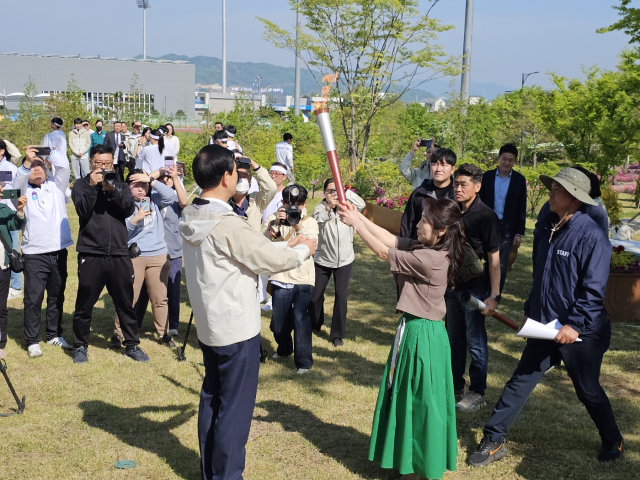 유미현 원장 채화 성화를 조길형 충주시장에게 전달받고 있다.사진=김의상 기자