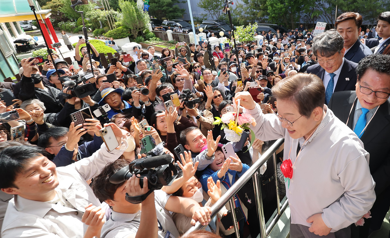 더불어민주당 이재명 대선 후보가 7일 전북 익산시 대한노인회 익산시지회에서 열린 노인회 간담회에 참석하던 중 어린이로부터 꽃다발을 받은 뒤 지지자들에게 들어보이고 있다. 2025.5.7 사진=연합뉴스. 