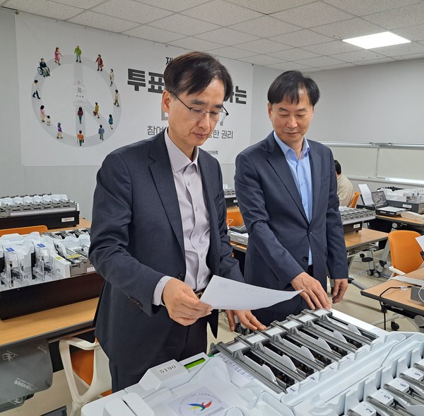 ▲ 세종특별자치시선거관리위원회위원장(김용찬/왼쪽)은 이번 대통령선거 개표소에서 사용할 투표지분류기 점검에 직접 참여하고 시험운영으로 출력된 개표상황표를 확인하고 있다. 세종특별자치시선거관리위원회 제공