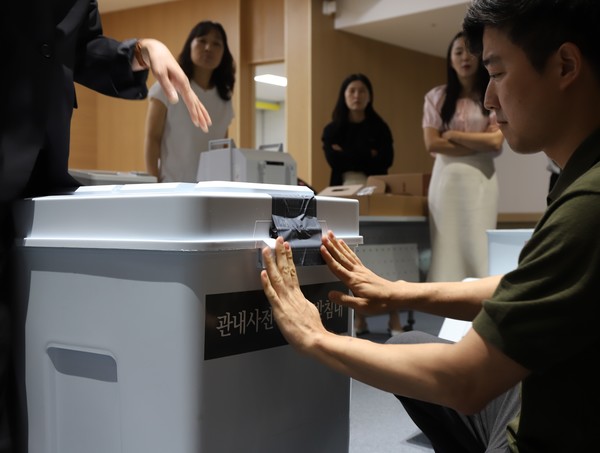 ▲ 27일 보람종합복지센터 다목적 강당에서 한 사전투표관리관이 사전투표함에 특수봉인지를 첩부하고 있다. 세종시선관위는 이날 오전 관내 24개 사전투표소의 사전투표관리관 등 48명을 대상으로 교육을 실시했다. 세종시선관위 제공