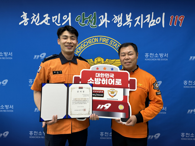 ‘소방히어로 37호’로 선정된 배진우 소방장(오른쪽)이 28일 강원 홍천소방서에서 감사장을 수여받고 기념촬영을 하고 있다.타이어뱅크㈜ 제공.