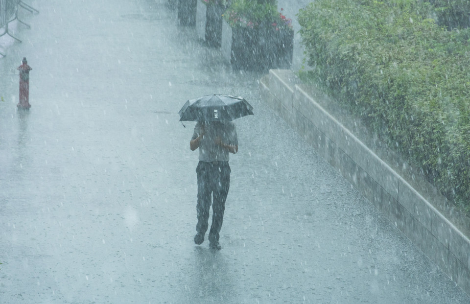 한 시민이 쏟아지는 소나기를 맞으며 이동하고 있다. 사진=연합뉴스.