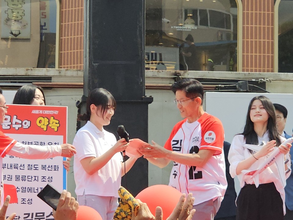 김문수 국민의힘 대선후보가 30일 충주 유세에서 이곳에 거주하는 박시현 양으로부터 해결 요구 현안이 담긴 손편지를 받고 있다. 사진=김의상 기자. 