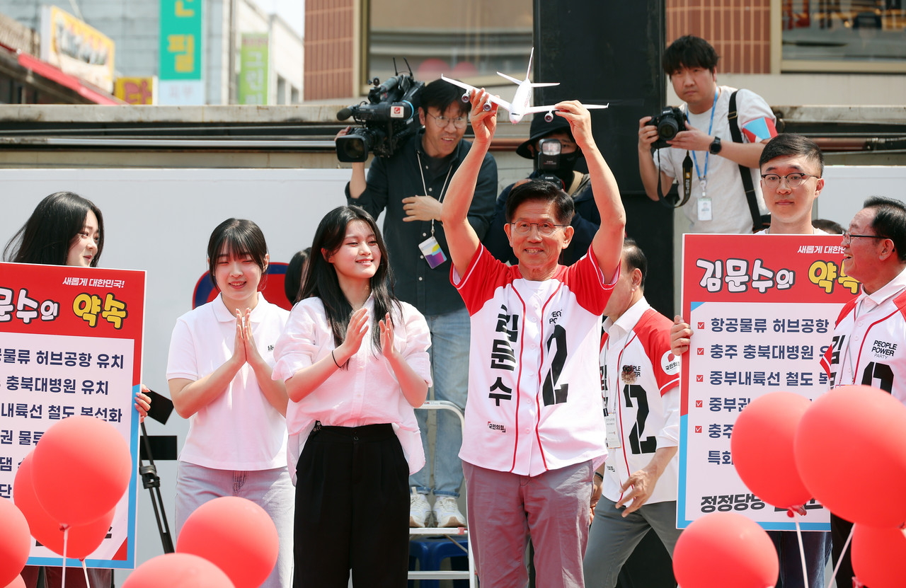 국민의힘 김문수 대선 후보가 30일 충북 충주시 젊음의 거리에서 열린 유세에서 '충주 항공물류 허브공항 유치' 라고 적힌 비행기 모형을 받고 있다. 2025.5.30 사진=연합뉴스. 