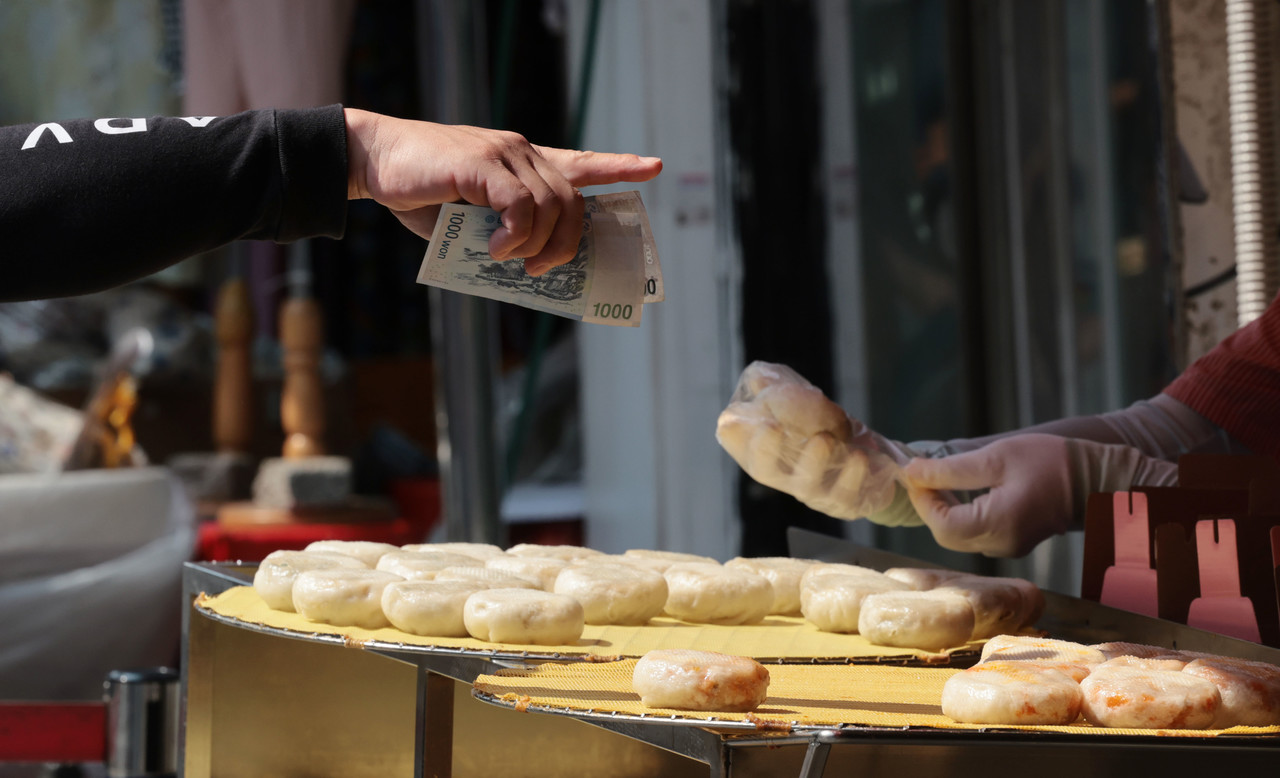 시장에서 한 시민이 간식거리를 구입하고 있다. 사진=연합뉴스.