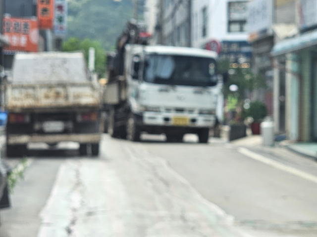 수안보 도심 상가 골목을 지난 14일 오후 굴삭기와 덤프가 상가 골목을 완전 차단하고 공사를 강행하고 있는 모습이다.사진=김의상 기자