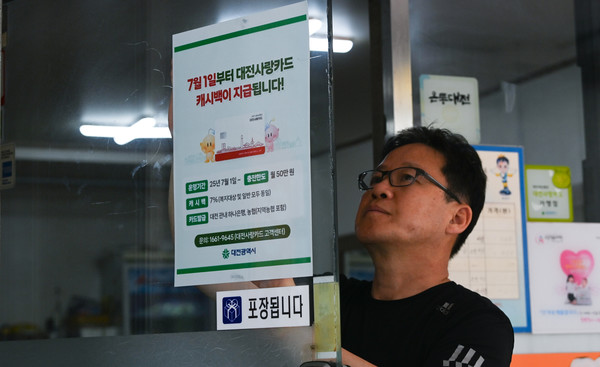 '대전사랑카드'가 7월 1일부터 본격 운영에 들어가는 가운데 30일 대전 유성구의 한 가맹점에서 점주가 관련 안내문을 붙이고 있다. '대전사랑카드'는 관내 하나은행과 농협에서 발급받을 수 있다. 김주형 기자 kjh2667_@cctoday.co.kr