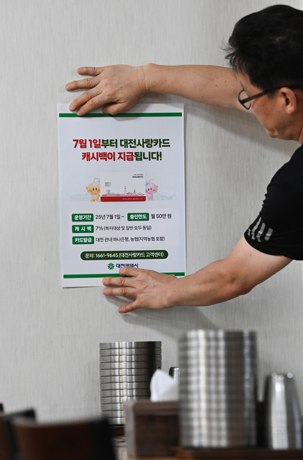 '대전사랑카드'가 7월 1일부터 본격 운영에 들어가는 가운데 30일 대전 유성구의 한 가맹점에서 점주가 관련 안내문을 붙이고 있다. '대전사랑카드'는 관내 하나은행과 농협에서 발급받을 수 있다. 김주형 기자 kjh2667_@cctoday.co.kr