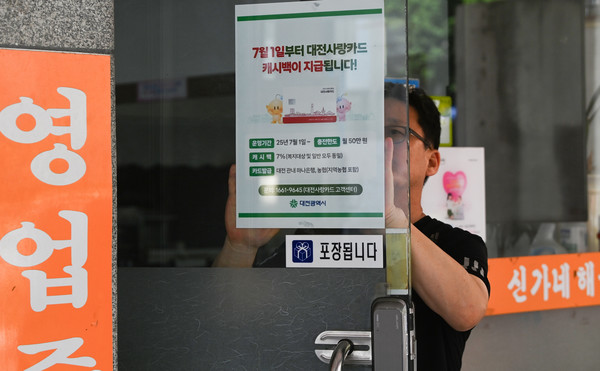 '대전사랑카드'가 7월 1일부터 본격 운영에 들어가는 가운데 30일 대전 유성구의 한 가맹점에서 점주가 관련 안내문을 붙이고 있다. '대전사랑카드'는 관내 하나은행과 농협에서 발급받을 수 있다. 김주형 기자 kjh2667_@cctoday.co.kr