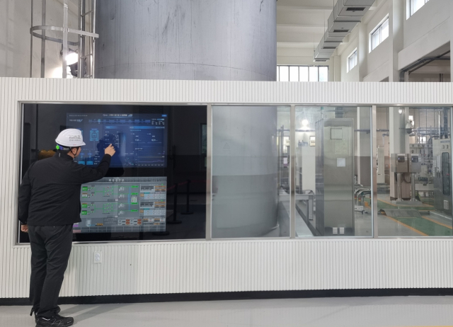 한국수자원공사 관계자가 경기도 화성에 있는 AI 정수장에서 약품주입동에 구현된 ‘스마트 미러’(터치형 화면)를 보며 정수처리에 필요한 약품주입 자율공정 현황 등을 살펴보고 있다. 공사 제공
