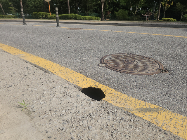 4일 오전 충주시 호암수청4길 도로에 땅꺼짐이 발생해 구멍이 뚫린 모습이다.사진=김의상 기자