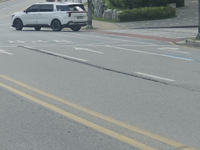 포장 공사 후 죠인트(이음매)가 차선 도색 위치가 아닌 차량 주행선에 시공돼 차량 무게를 견디지 못하고 균열이 발생한 모습, 시공 편의 위주 공사로 도로 하자가 반복되는 현장을 보여주고 있다.사진=김의상 기자