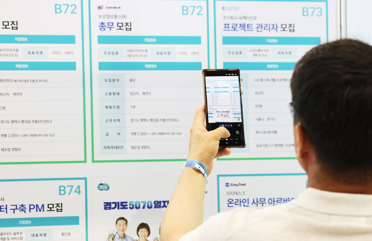 9일 경기도 수원시 권선구 수원메쎄에서 열린 '경기도 5070 일자리 박람회'에서 구직자들이 채용정보를 휴대전화로 찍고 있다. 2025.7.9