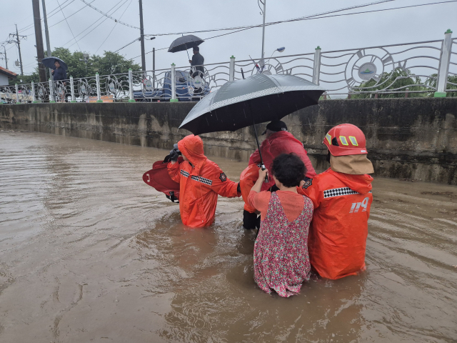 17일 오전 충남 공주시 유구읍 유구리의 한 마을 50가구 중 20가구가 비로 인해 침수된 가운데 마을 주민이 소방대원에 의해 구조됐다. 충남소방본부 제공