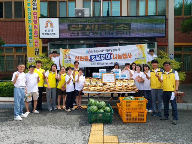 신관동지역사회보장협의체 위원들이 물품을 전달하기 위해 화이팅을 하고 있는 모습.사진=김익환 기자