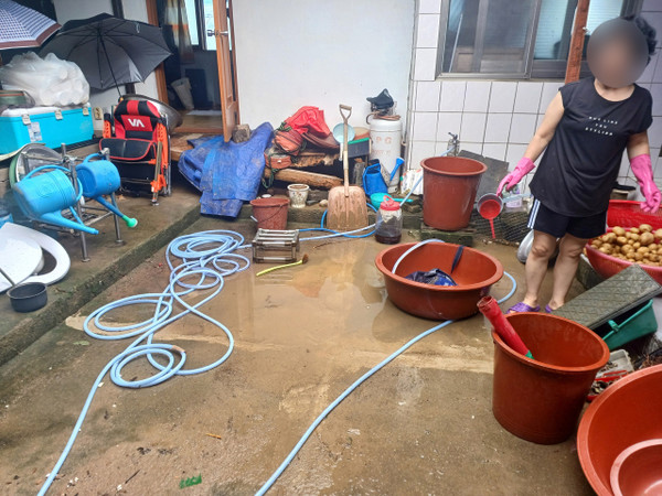 예산군의 한 민가에서 폭우 피해를 입은 집을 정리하고 있다. 사진=권혁조 기자.