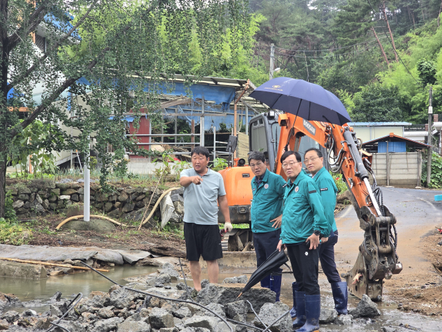 김돈곤 청양군수는 안전총괄과장과 호우 피해 현장을 찾아 긴급 점검을 하고 있다.