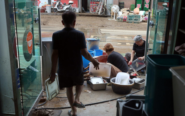 21일 경남 산청군 신안면의 한 식당에서 식당 관계자가 흙탕물에 젖은 조리 도구를 세척하고 있다. 사진=연합뉴스