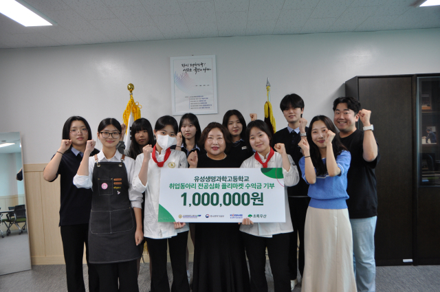 유성생명과학고등학교 학생과 교직원들이 ‘전공심화 플리마켓 프로젝트’ 활동 수익금 기부 팻말을 들고 기념촬영하고 있다. 초록우산 대전지부 제공