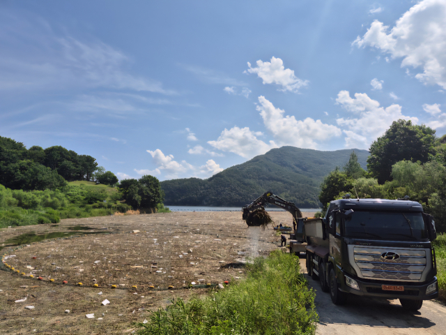 23일 전북 진안 용담댐 상류 일대 부유물 수거 모습. 포집된 부유물을 굴삭기를 동원해 운반 후 선별작업 등을 거쳐 처리할 예정이다. 한국수자원공사 제공