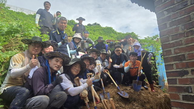 ▲수해 복구 작업을 마친 계룡시청 직원들이 무더위 속 잠시 자리에 앉아 땀을 식히며 휴식을 취하고 있다.