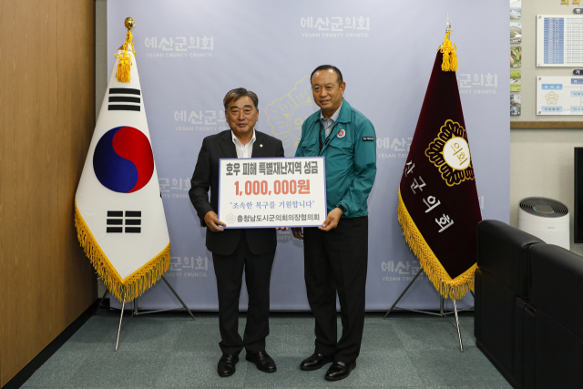 예산군의회를 찾아 수해복구 성금을 전달하고 있는 충남시군의회협의회 김경제 회장(사진 왼쪽)사진=서천군의회 제공.