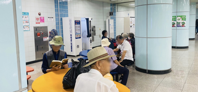 8울 8일 대전 지하철 역 내 노인들이 더위를 피해 담소를 나누고 책을 읽고 있는 모습. 사진=최광현기자.