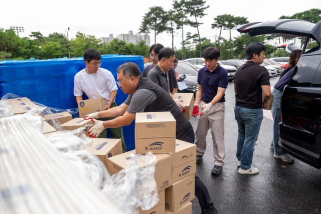 지난 6일 증평군청 공무원들이 단수사태로 어려움을 겪고 있는 각 가정에 공급할 물을 개인용 차량에 옮겨 싣고 있다. 증평군 제공